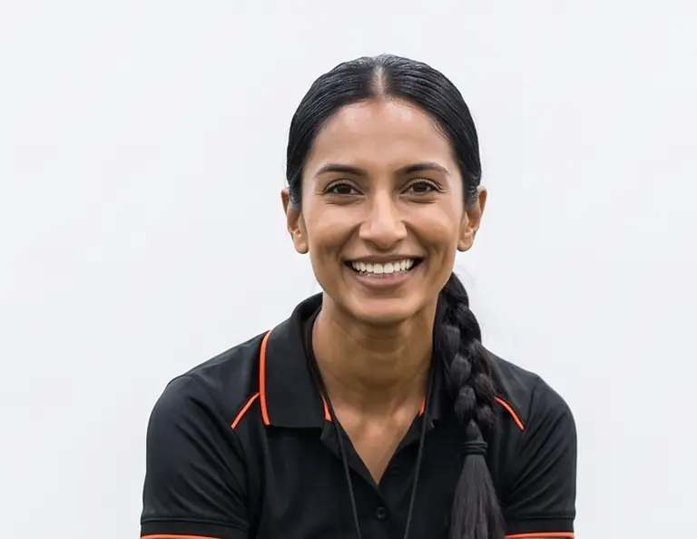 Youth soccer coach smiling during a skills clinic at an indoor sports facility